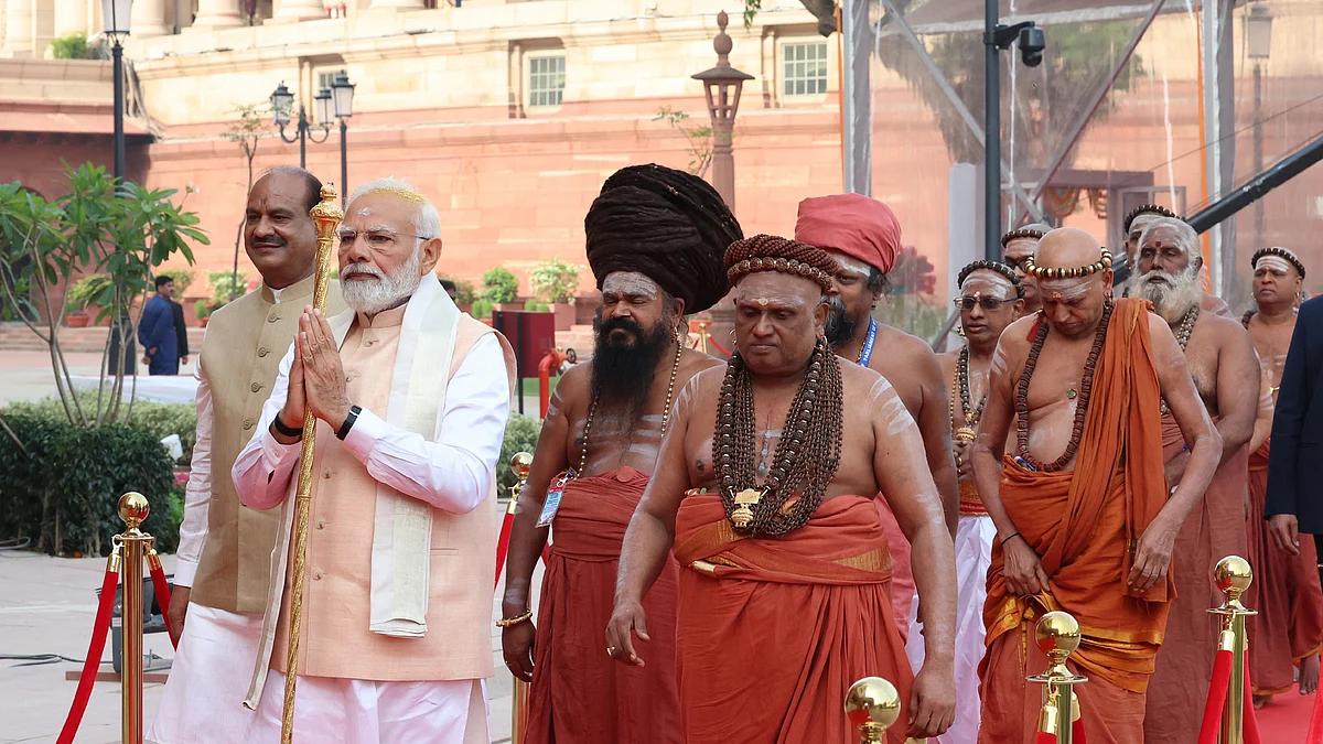 PM Modi holding the sengol with Lok Sabha speaker Om Birla (left) and a posse of Hindu priests in tow (Photo: PIB)