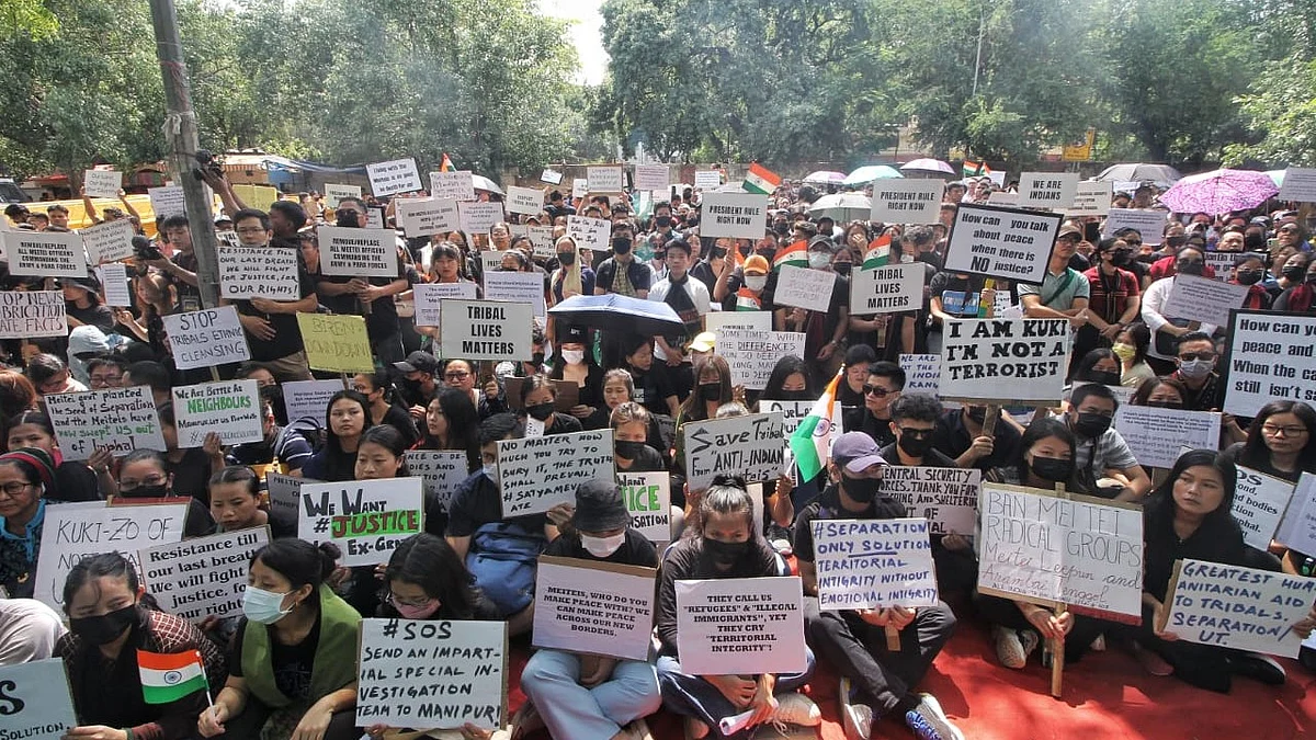 Members of the Kuki tribes hold banners & Indian flags while protesting against the killing of tribals in their home state Manipur, in New Delhi (photo: Vipin/National Herald)