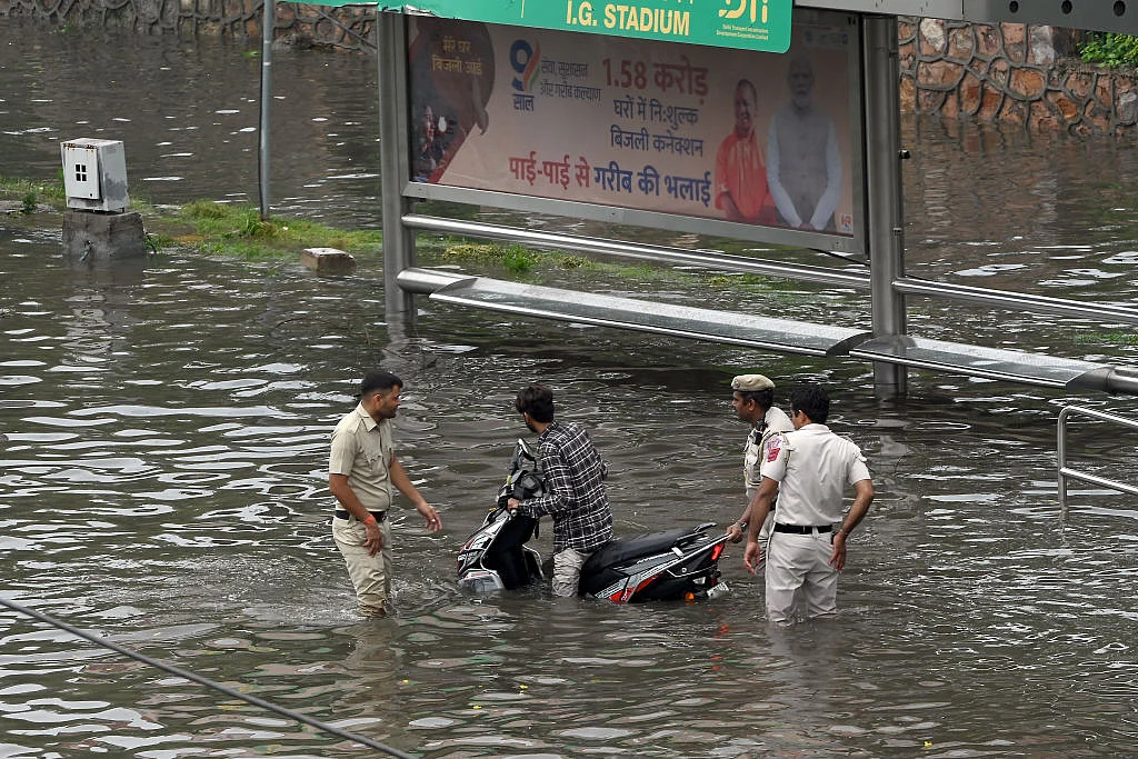 Police personnel helping a motorcyclist stuck on the flooded streets (Photo: Getty Images)