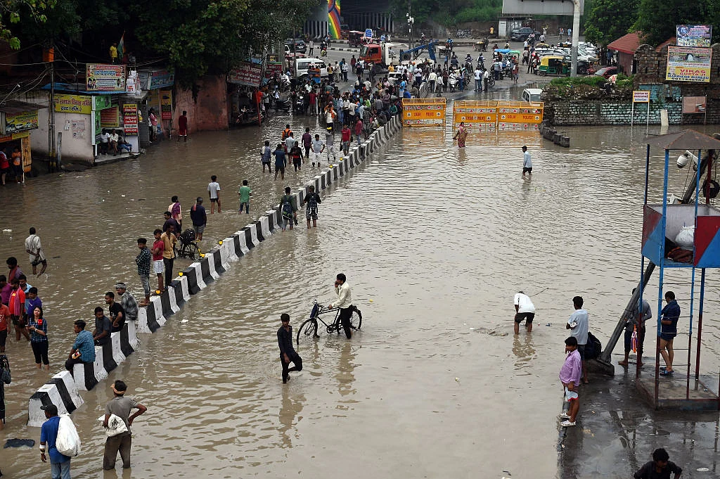 People on a flooded street in New Delhi (Photo: Getty Images)