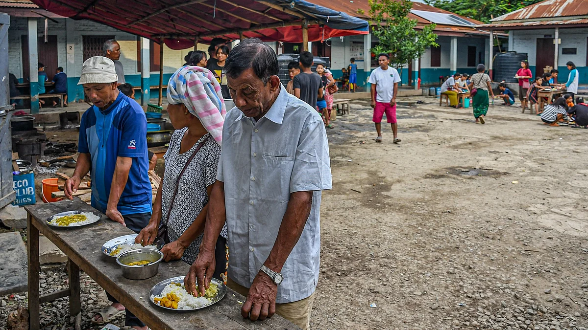 Displaced people take food at a relief camp at Saidan village. (Photo: Getty Images)