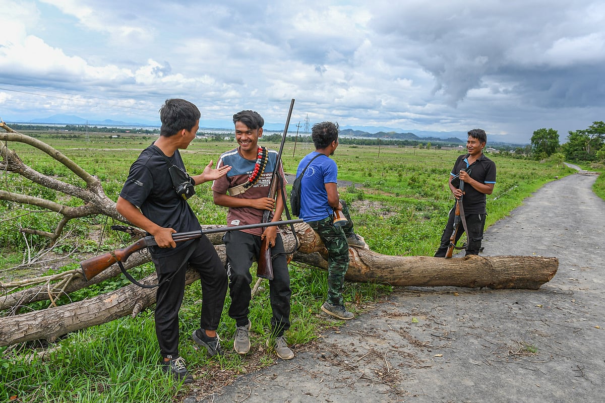 Kuki youth from Khousabung village share a light moment as they stand guard at the Kangvai checkpoint near the Indo–Myanmar border in Churachandpur, Manipur (photo by Biplov Bhuyan/SOPA Images/LightRocket via Getty Images)