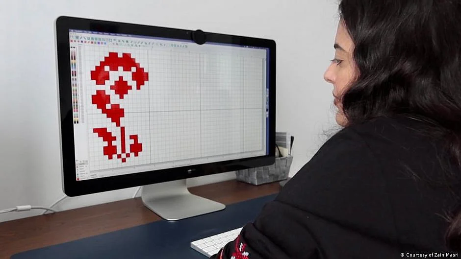 Zain Masri cross-stitches patterns on her computer (Photo: DW)