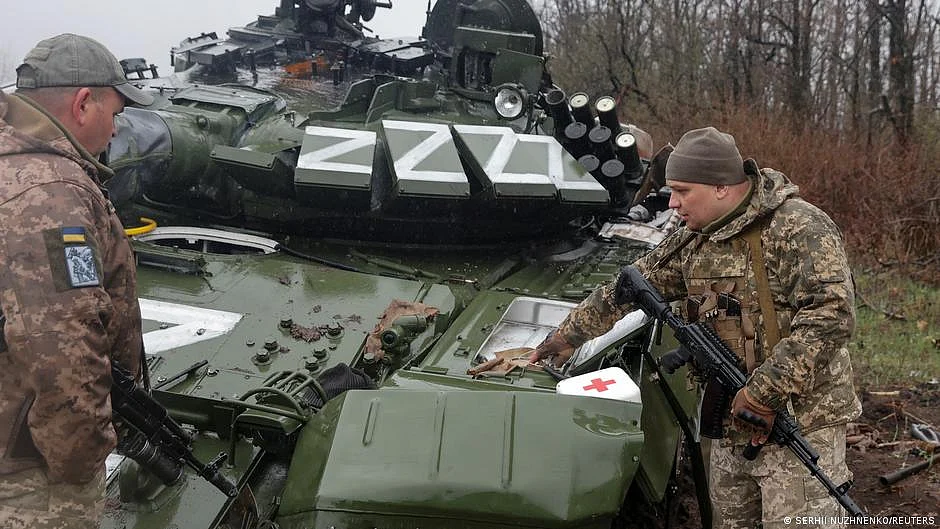 Ukranian service members inspect a damaged Russian tank T-72 BV (photo: DW)