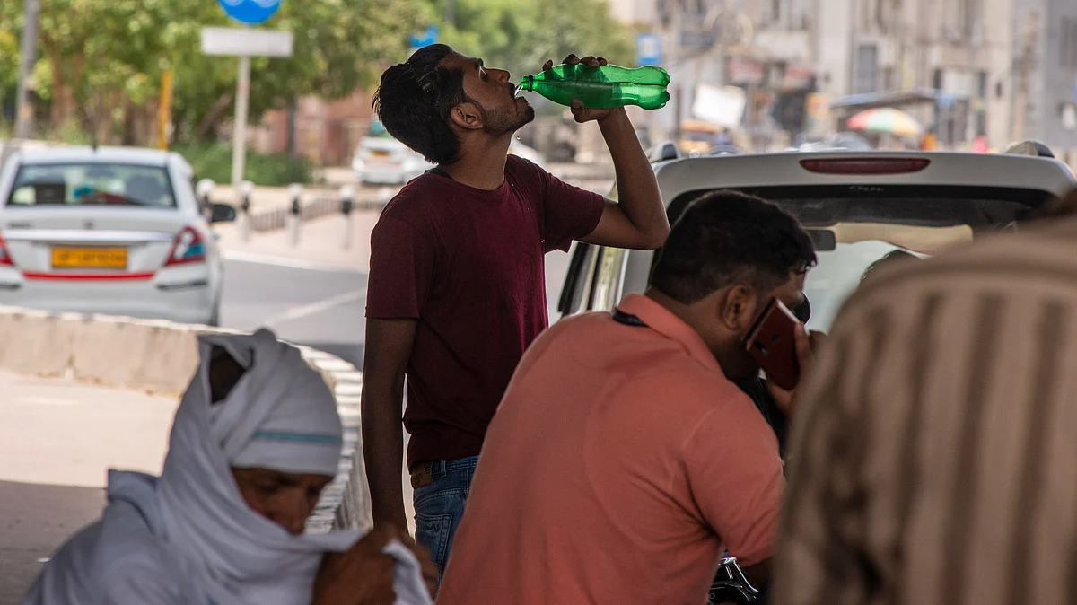 A man drinks water from a bottle to quench his thirst at the roadside during a hot day in New Delhi (Photo: Getty Images)