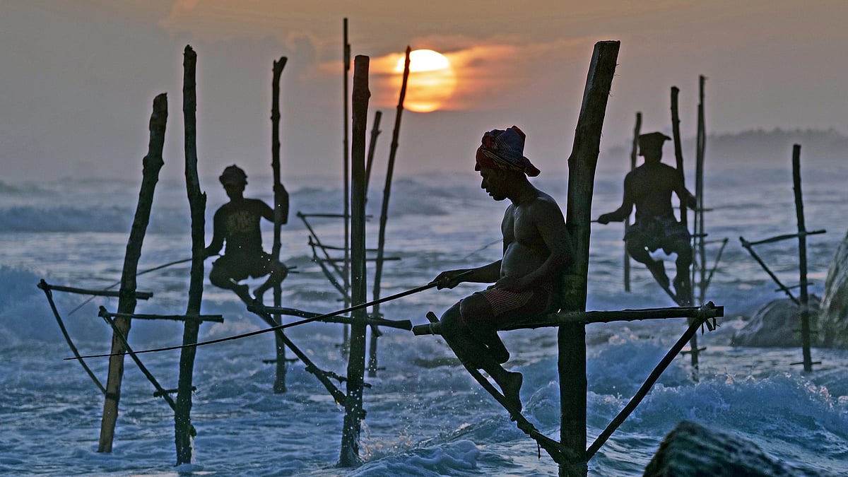 Men fish on stilts in the Indian Ocean in Weligama,  Sri Lanka  (Photo: Getty Images) 