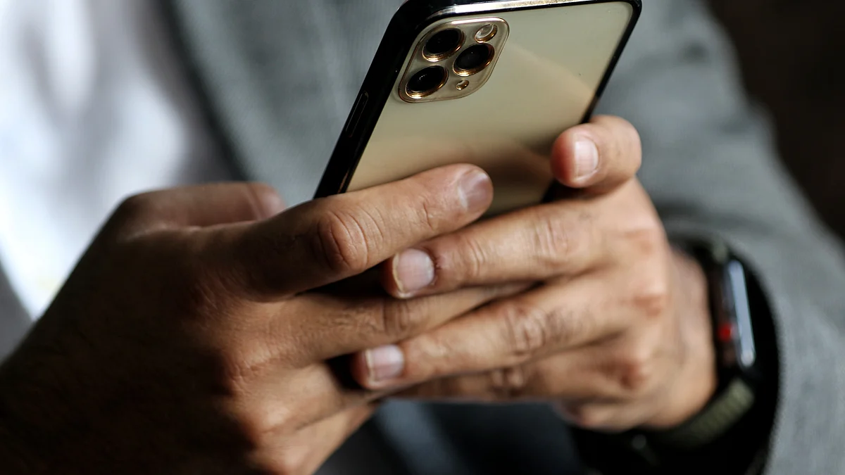 A man uses an iPhone 13 Pro Max at a restaurant in Baramulla Jammu and Kashmir India on 19 March 2022 (Photo by Nasir Kachroo/NurPhoto via Getty Images)