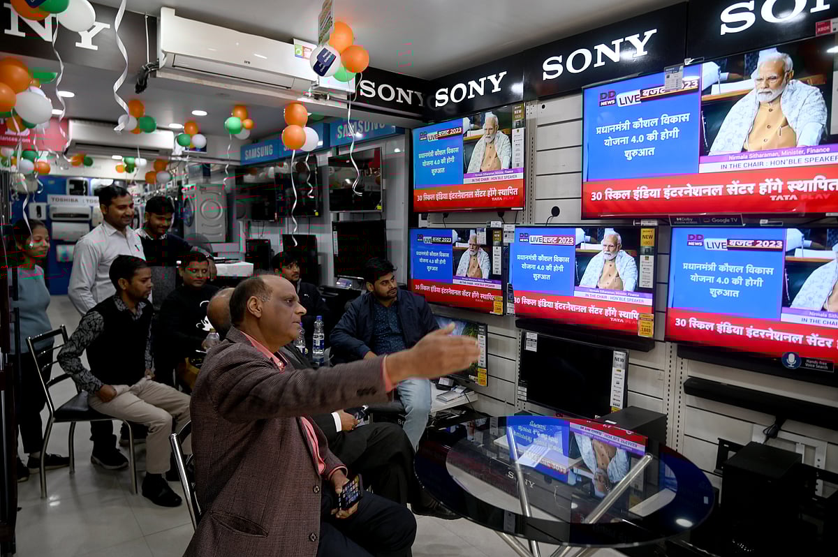 Live telecast of Union Budget 2023 watched by market association members in an electronics store, with tricolour decorations. Prime Minister Narendra Modi is the focus on the screen, though he does not seem to be speaking (photo: Sunil Ghosh/Hindustan Times via Getty Images)