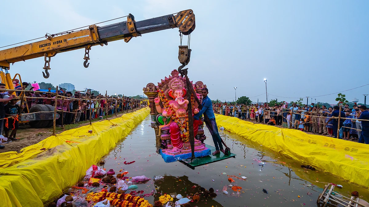 Representative image of a  human-sized, plaster-of-Paris Ganesha idol being lowered into a canal by a crane's boom for immersion. The Madras HC's order on Ganesh idol materials challenged in SC (photo: Saurabh Sirohiya/NurPhoto via Getty Images)
