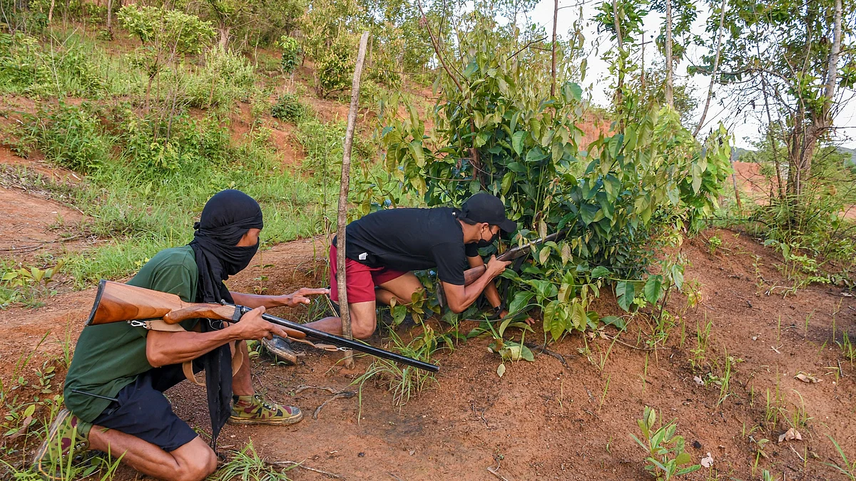 A squad leader in Manipur's Churachandpur village trains a youth to hide and shoot during jungle combat training (photo: Getty Images)