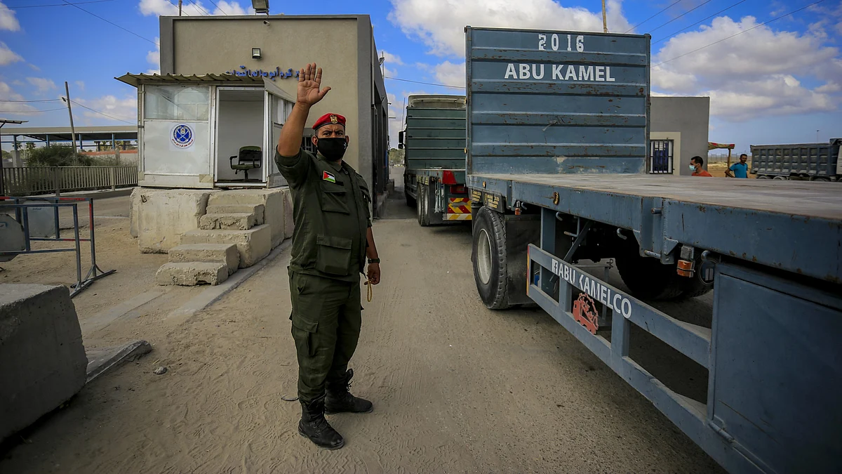A member of Palestinian Hamas guides trucks entering the Kerem Shalom crossing in the southern Gaza Strip city of Rafah (photo: Getty Images)