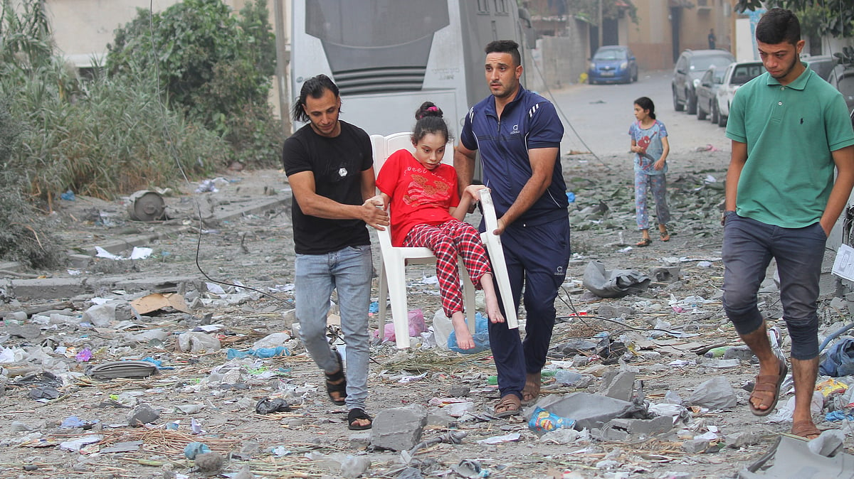 Palestinian citizens evacuate their homes damaged by Israeli airstrikes in Gaza City. (photo: Getty Images)