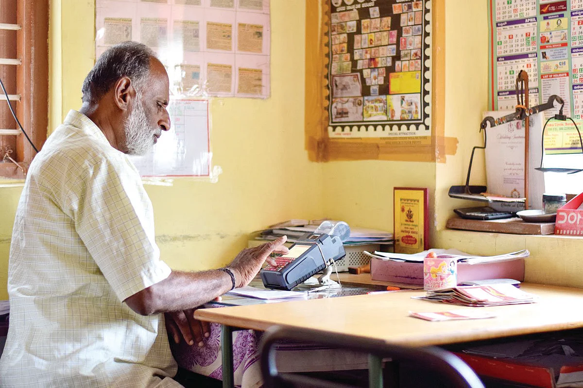Renuka at work as a gramin dak sevak in his one-room office in Devarayapatna town in Karnataka’s Tumkur district (photo: Hani Manjunath/PARI)