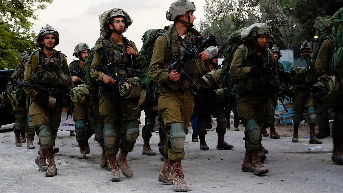 Offline and online: Israeli soldiers walk through Kibbutz Be'eri four days after the 7 October Hamas attacks near the border with Gaza (photo: Getty Images)