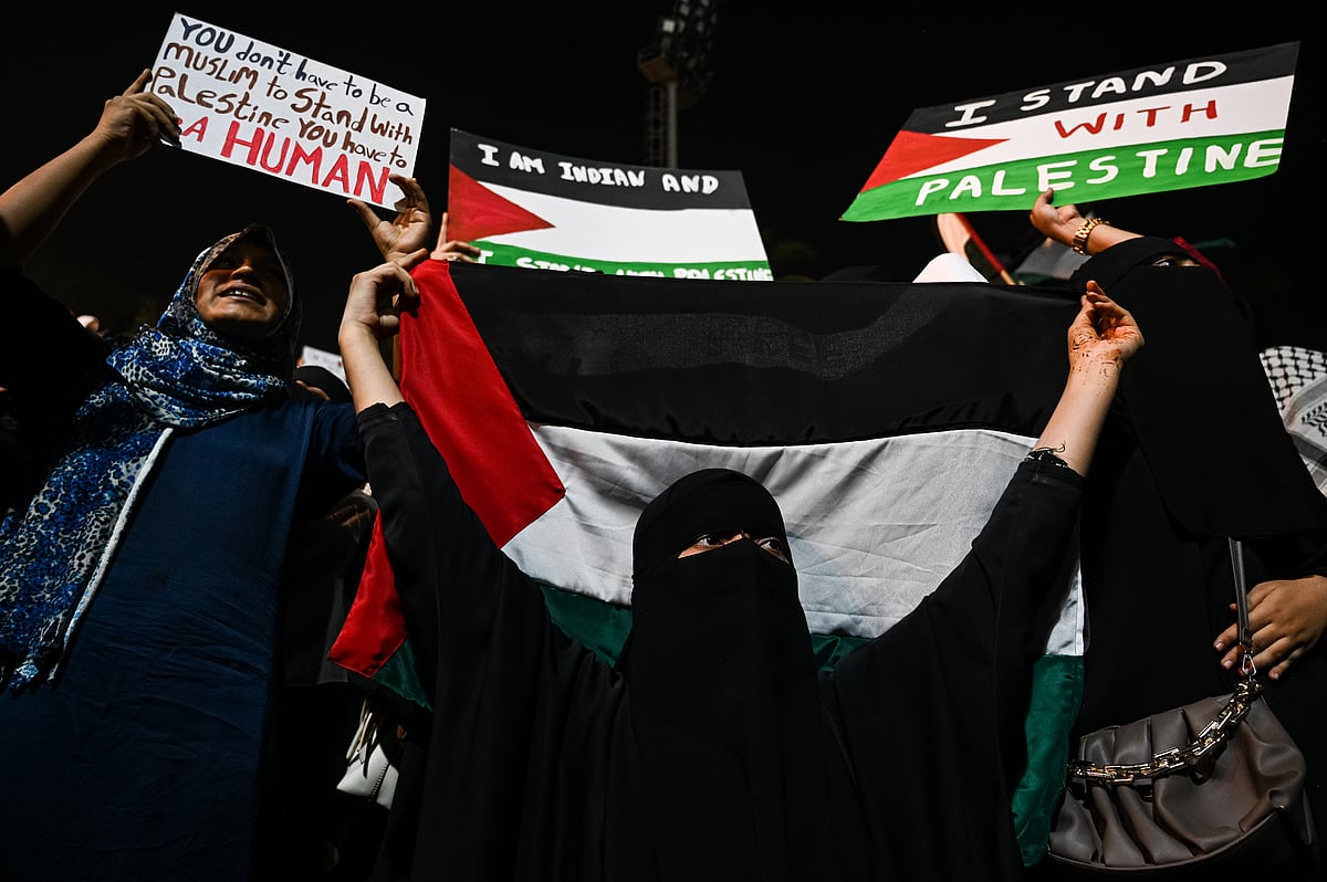 A woman holds the Palestinian flag at a public gathering in solidarity with Palestinians in Gaza, in Mumbai on 20 October (photo: Getty Images)