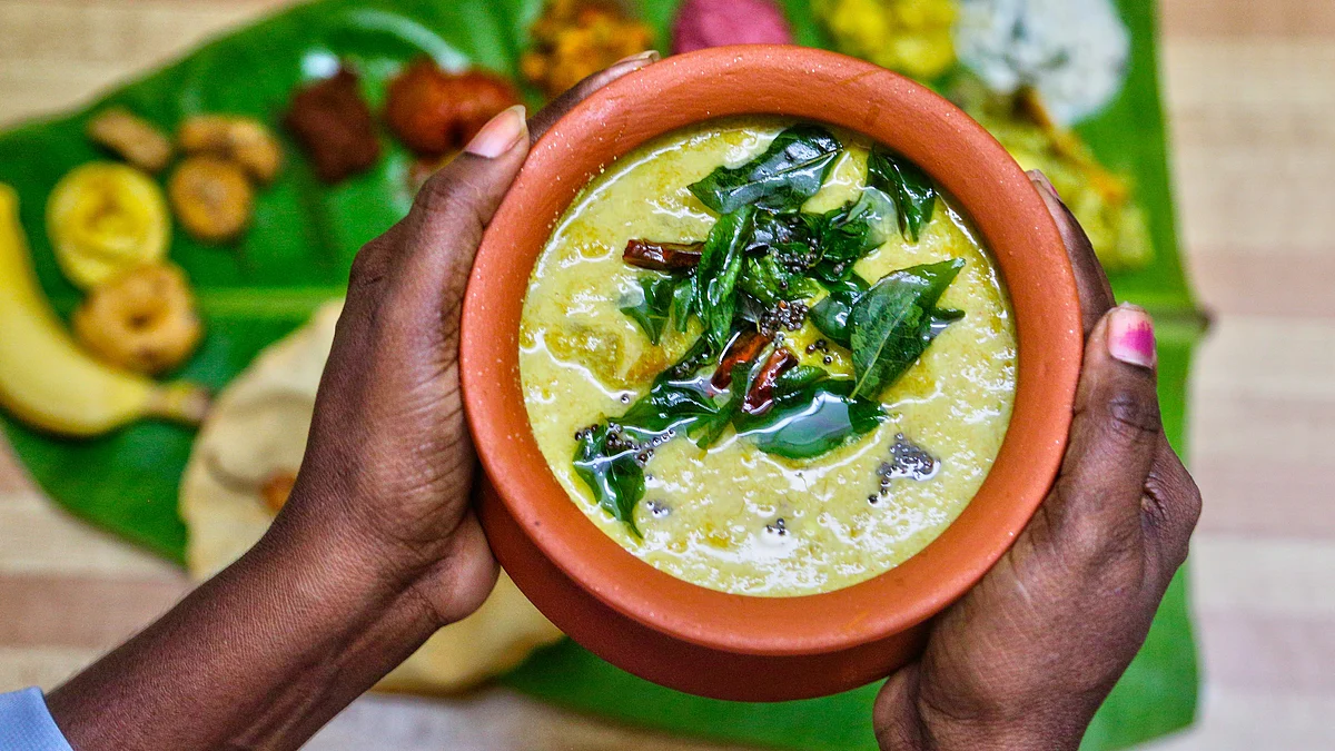 Representative image of a vegetarian sadhya served on a banana leaf, with a pot of maambazha pulissery (mango yoghurt curry) in the foreground (photo: Creative Touch Imaging Ltd./NurPhoto via Getty Images)