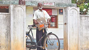 Renuka with his bicycle on which he travels to different villages, delivering post (photo: Hani Manjunath/PARI)