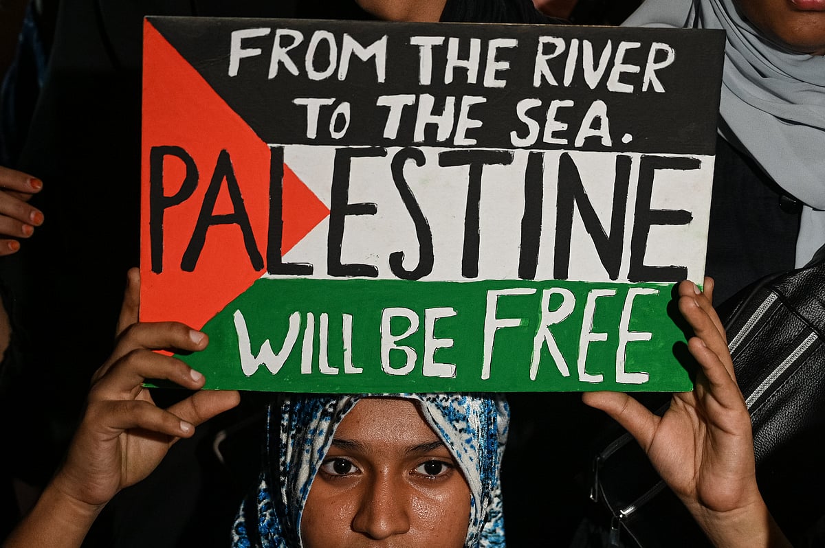 A woman holds a placard with the famous slogan, 'from the river to the sea, Palestine will be free', in Mumbai on 20 October (photo: Getty Images)