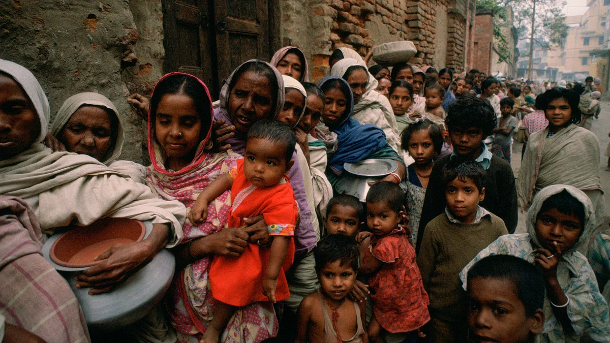 Representative image of women carrying pots with children in an early morning food queue (Photo by Tim Graham/Getty Images)