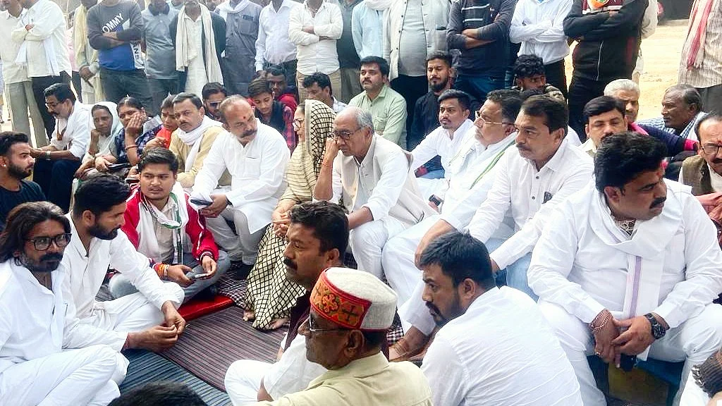 Digvijaya Singh (seated, centre) has promised to continue the sit-in until action is taken against the BJP candidate (photo: @digvijaya_28/ X)