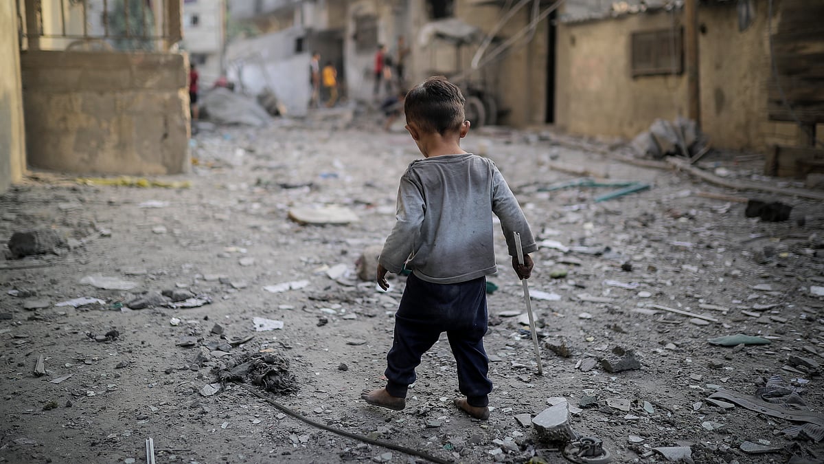 A child is seen among the rubble of destroyed buildings as Israeli airstrikes continue in Gaza (Photo:  Belal Khaled/Anadolu via Getty Images)