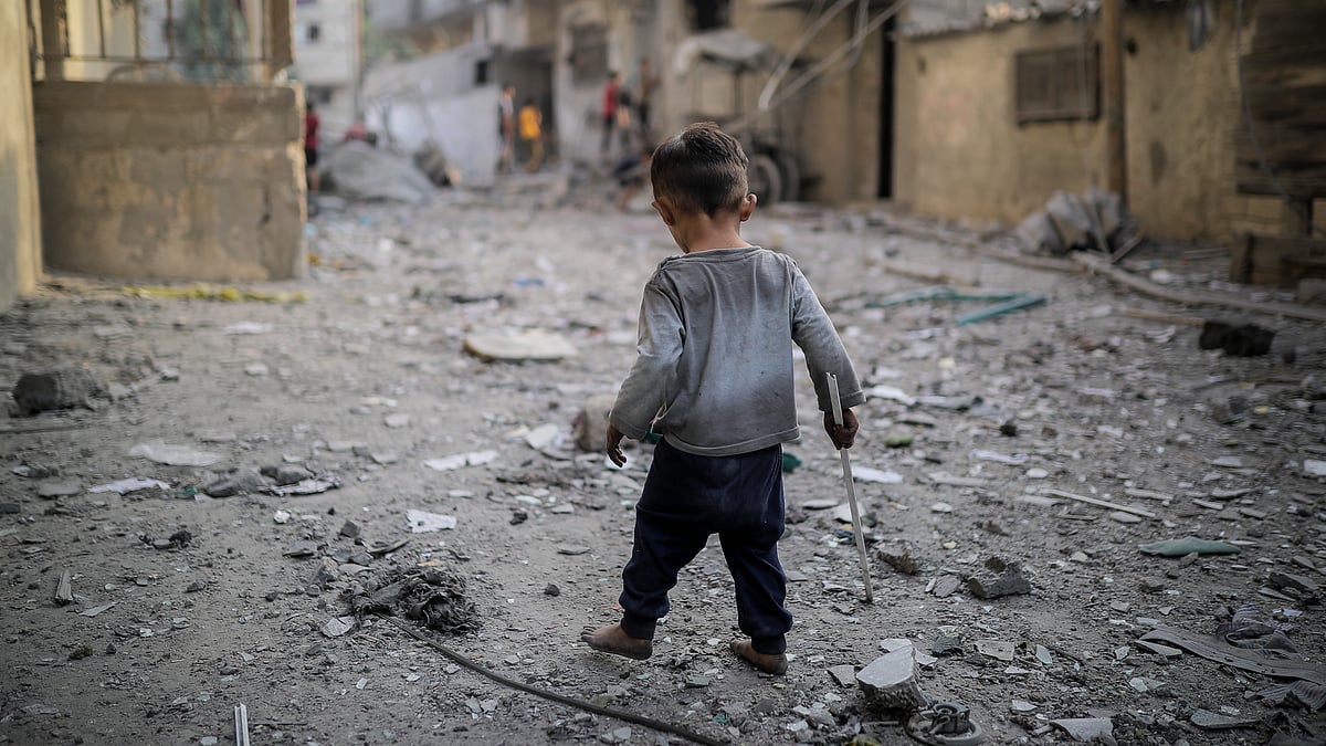 A child is seen among the rubble of destroyed buildings as Israeli airstrikes continue in Gaza (Photo:  Belal Khaled/Anadolu via Getty Images)