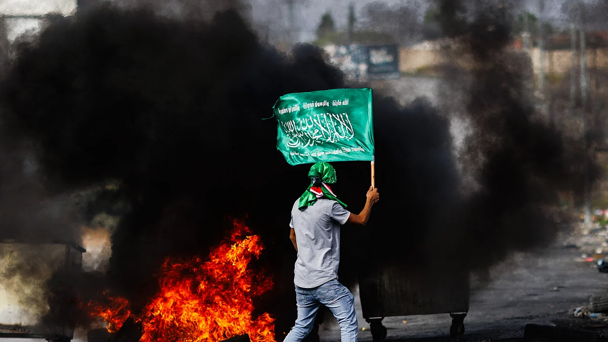 Palestinian youths waving Hamas flags clashed with Israeli Defence Forces at a checkpoint in Ramallah, West Bank on 27 October (photo: Getty Images)