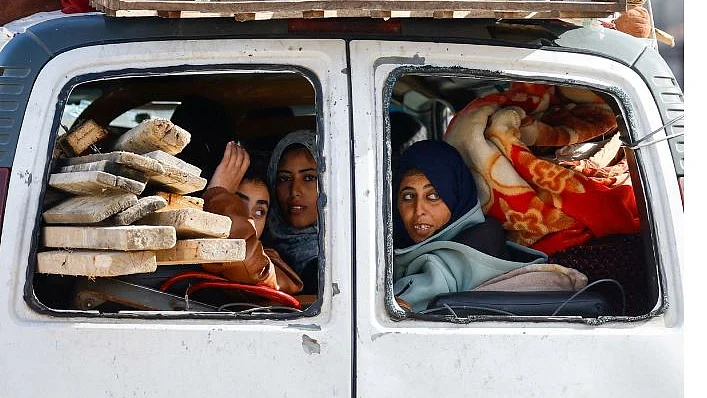 Inhabitants of Gaza crowd into a vehicle for safety and shelter with whatever essential supplies they can gather; thousands are now living in makeshift shelters in the streets, their homes having been destroyed (photo; IANS)