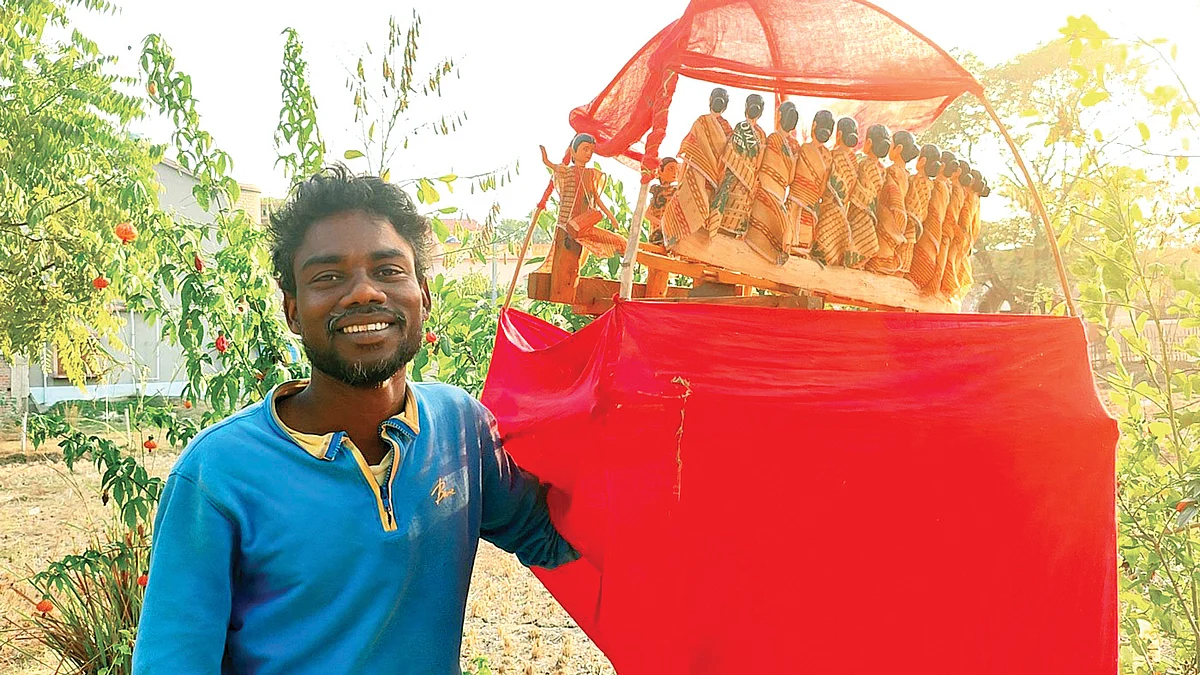 Adivasi performer Tapan Murmu and his Chadar Badni puppets under their red cloth shade and wrapping, one of the few practitioners remaining of this traditional Santhal performance art (photo: PARI)
