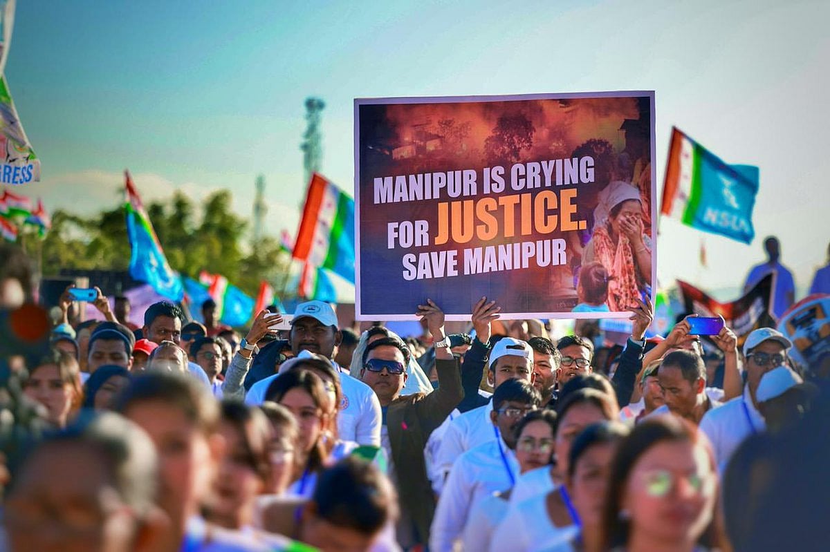Participants in the Bharat Jodo Nyay Yatra set out from Thoubal, Manipur, on foot, waving the Indian tricolour as well as various party banners, including the blue of the NSUI. Here they carry a placard showing a fire burning in Manipur, with the legend 'Manipur is crying for JUSTICE. Save Manipur' (photo @INCindia/X)