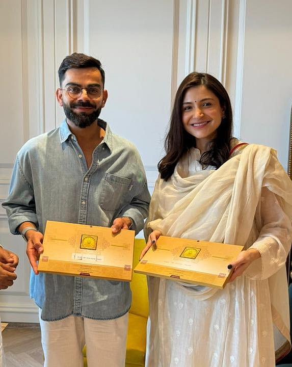 Virat Kohli (left) shows off the Ayodhya Ram Mandir inauguration invites along with his wife (photo courtesy @niiravmodi/X)