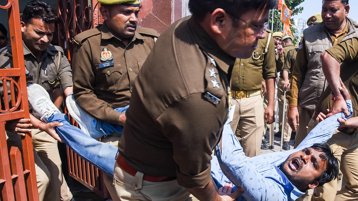 Police personnel detain a candidate during their protest over 'paper leak' in Lucknow on Friday
