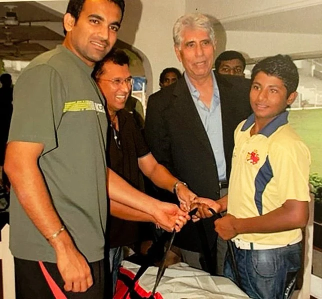 Shyam Bhatia (centre) hands a kit bag to 13-year-old Sarfaraz Khan in the presence of Zaheer Khan (left) and Kiran More (courtesy: Shyam Bhatia)