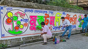 TMC workers paint a wall as part of party candidate Mukut Mani Adhikari's campaign for the Lok Sabha elections in Nadia on 11 March (photo: PTI)
