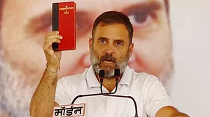 Rahul Gandhi shows a copy of the Indian Constitution at a public meeting in Madhya Pradesh on 30 April 2024 (photo: PTI)
