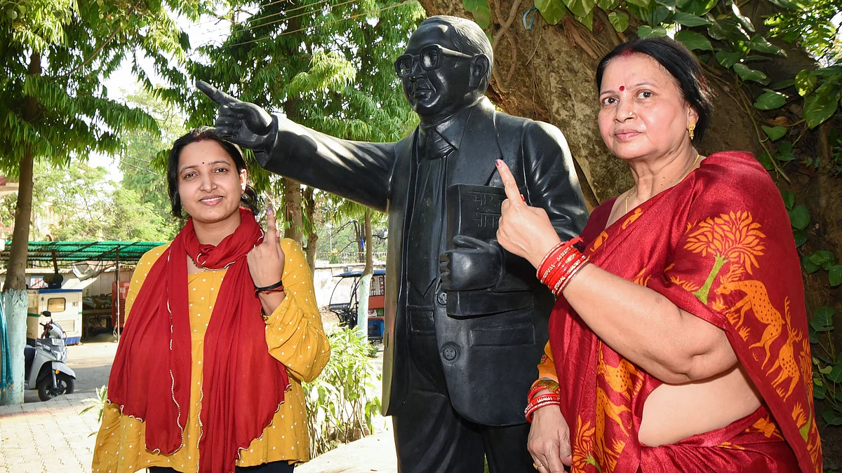 Voters pose next to a statue of B.R. Ambedkar in Bhagalpur, Bihar (photo: PTI)
