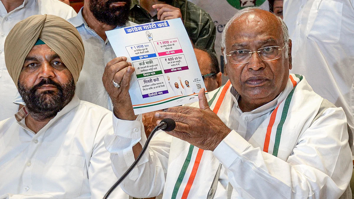 Mallikarjun Kharge holds up the Congress 'guarantee card' (photo: PTI)