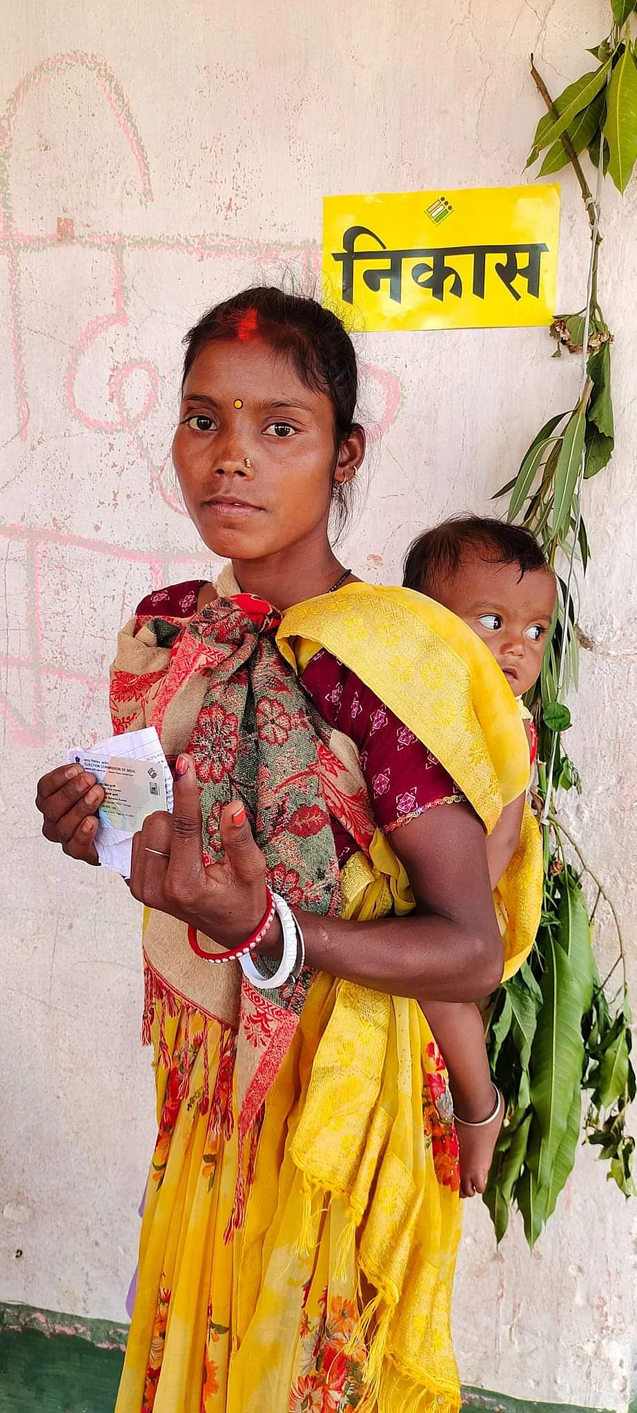 Voting with baby worn on the back, in Jharkhand (photo courtesy @ceojharkhand/X)