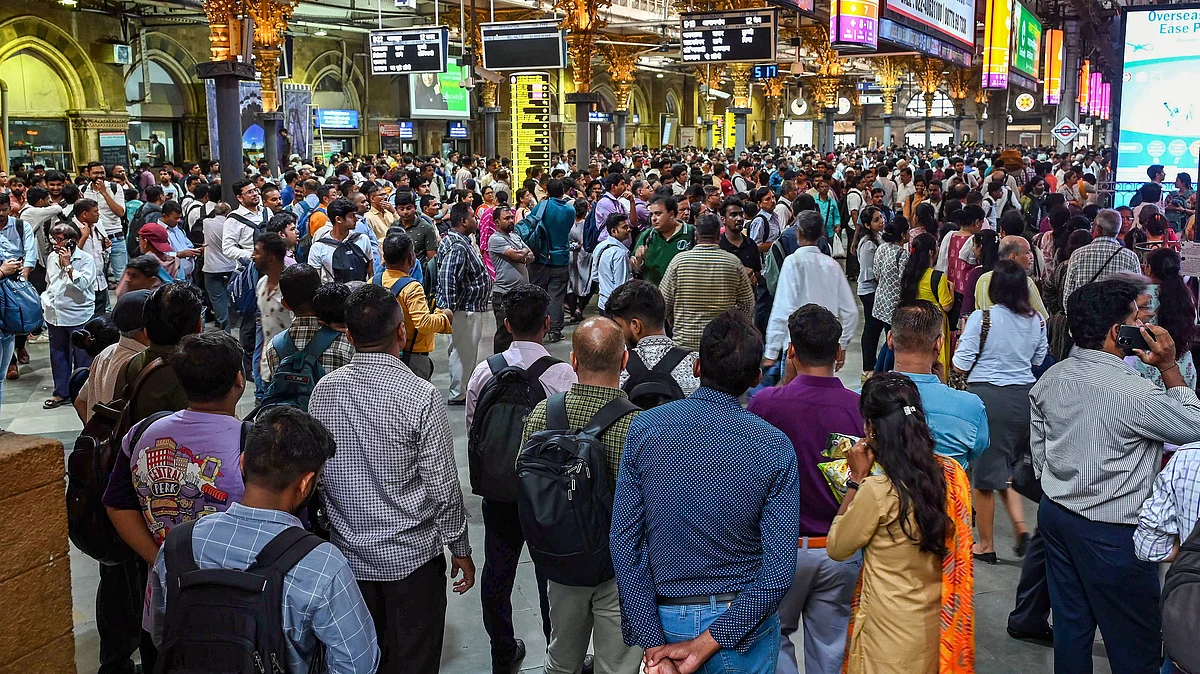 Commuters wait at the Chhatrapati Shivaji Maharaj Terminus after train services disrupted due to heavy rain