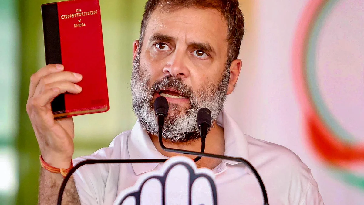 Congress leader holds up the Constitution of India as he speaks of safeguarding the rights of the tribes of India enshrined in it, at a rally in Madhya Pradesh on 6 May 2024 (photo: PTI)