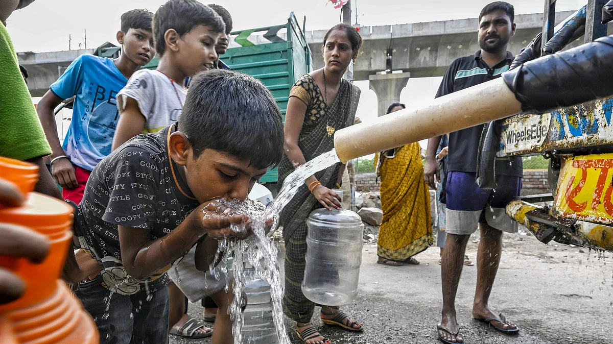 Delhiites wait to collect drinking water on 25 June (photo: PTI)