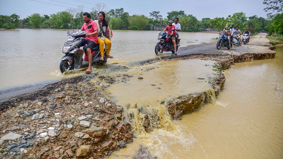 Bikers wade through a flooded area
