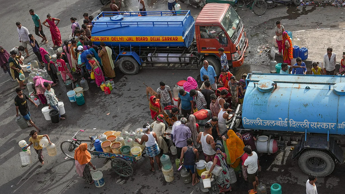 People in Delhi queue up to collect drinking water from a Delhi Jal Board tanker