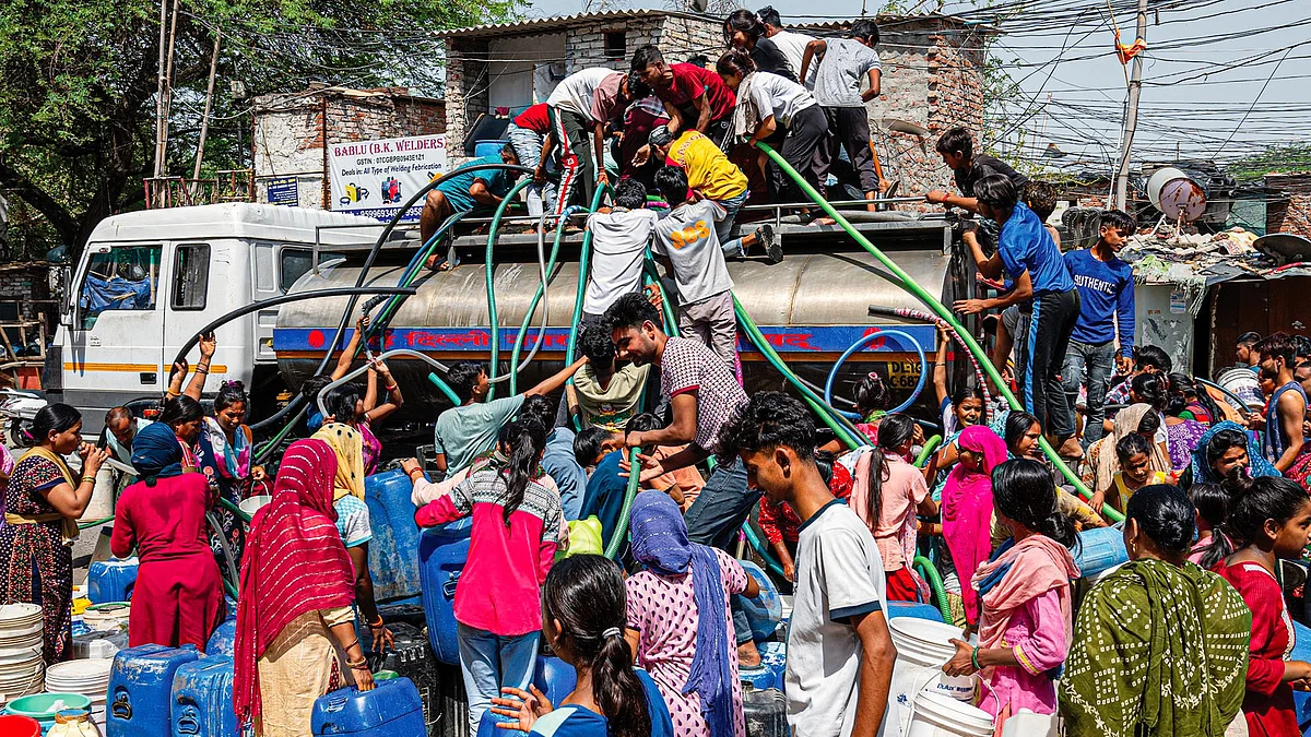Residents crowd around a water tanker in Delhi 