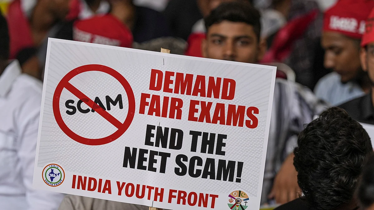 An agitator holds a placard during a protest over the alleged irregularities in NEET 2024 results