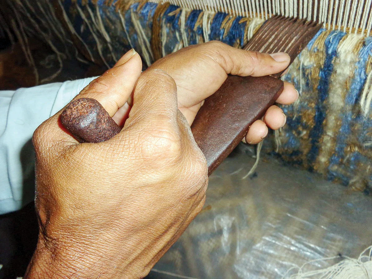 A panja (iron comb) is used to settle the stitches
