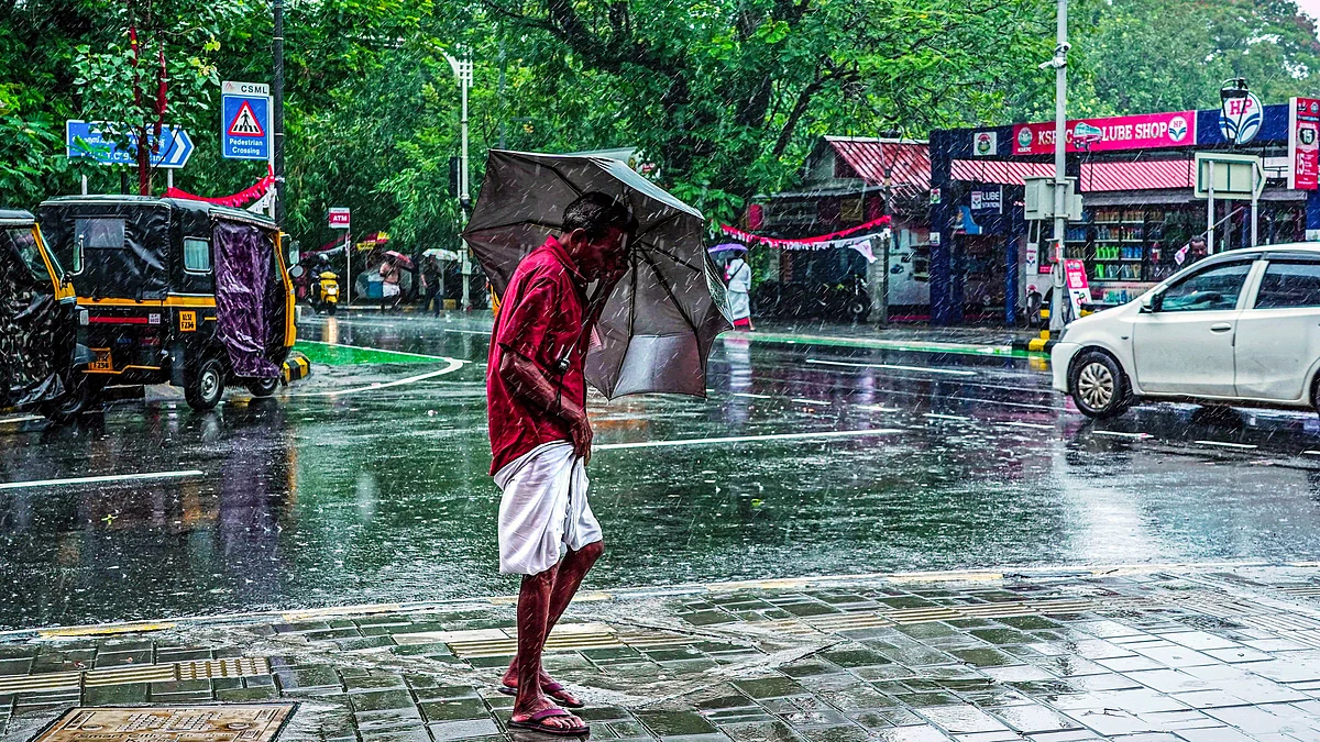A man walks through heavy rainfall in Kochi 