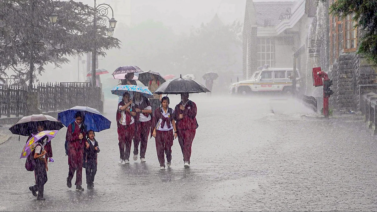 Students protest themselves from rain in Shimla on 7 September (photo: PTI)