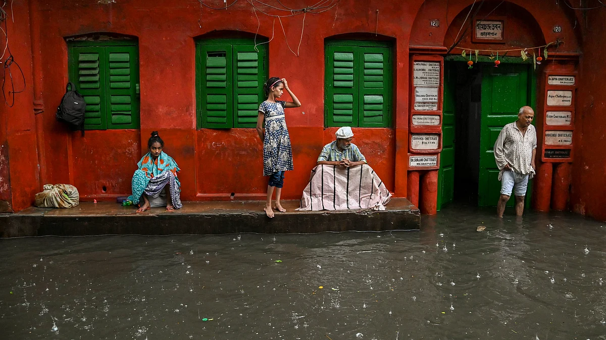 People take shelter during heavy rainfall in Kolkata on 25 October (photo: PTI)