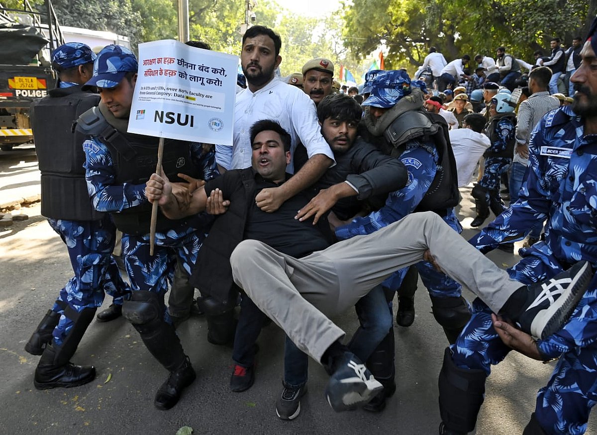 A protestor holds a placard saying 'stop denying right to reservation and start applying constitutional law'